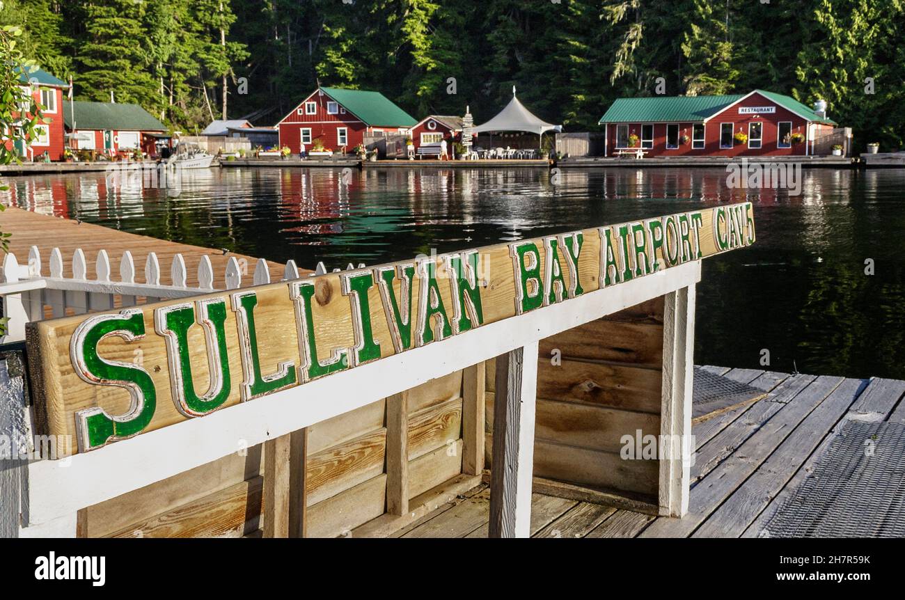 A painted wooden sign identifies the seaplane dock at Sullivan Bay, a Water Aerodrome and floating village in BC's remote Broughton Archipelago. Stock Photo