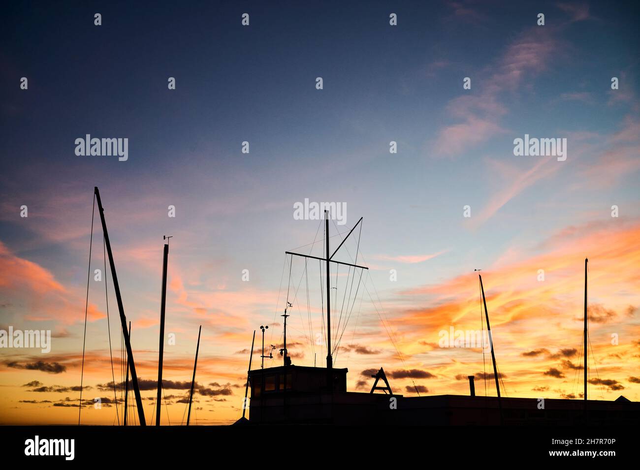 Boat masts silhouetted against setting sun Stock Photo - Alamy