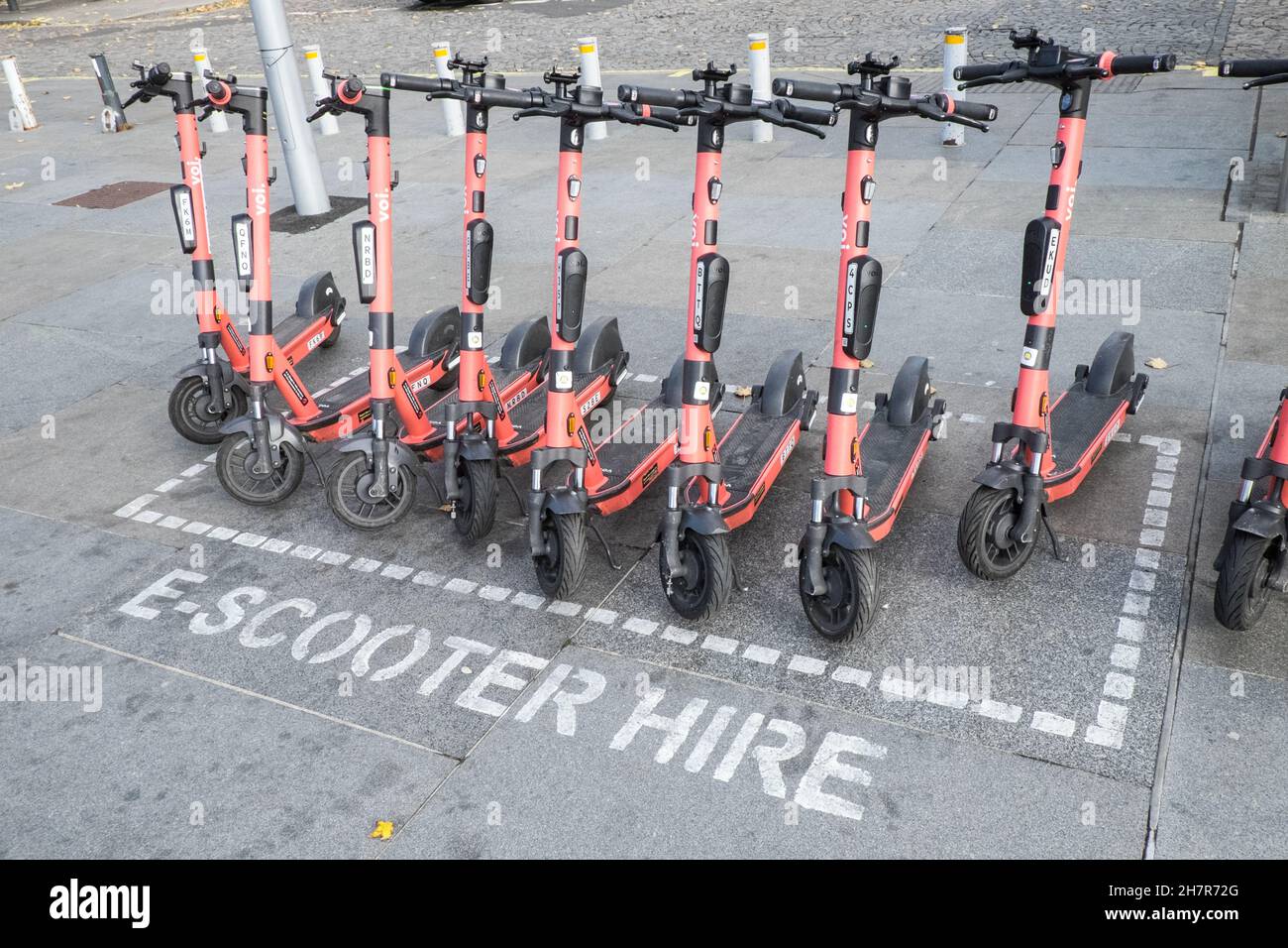 E-scooters,scooter,Electric scooters,pink,red,scooters ,owned,by,Voi,company,on,the,street,for,hire,rent,via,an,app,as,a,trial,period,to,see,if,they,are,safe,and,suitable,for,general,public,usage.Illegal,in,most,cities,in,UK,Liverpool,Merseyside,north  ...