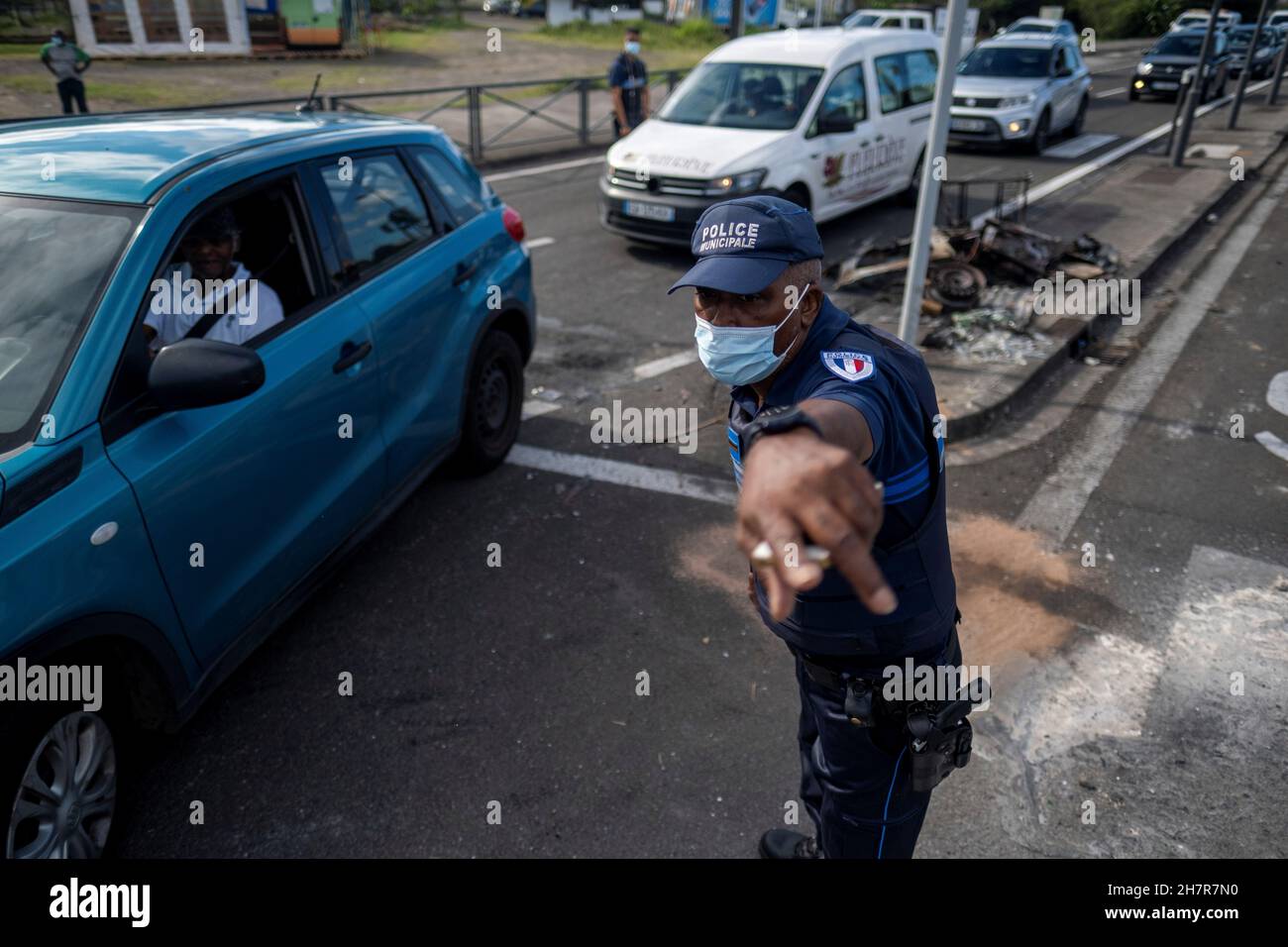 A police officer directs traffic to avoid barricades after unrest