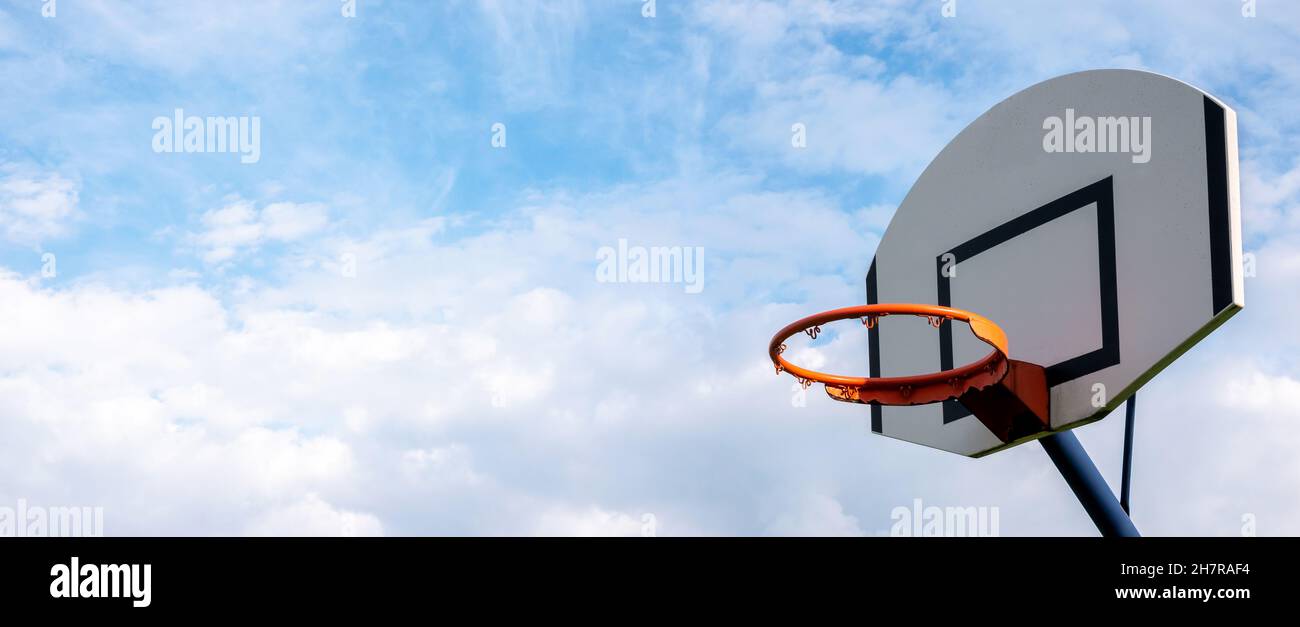 Basketball hoop without a net on cloudy sky simple abstract sport wide