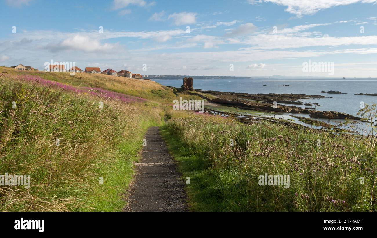 The Fife Coastal Path approaches ancient Seafield Tower on the way from Kinghorn to Kirkcaldy, Fife, Scotland. Stock Photo