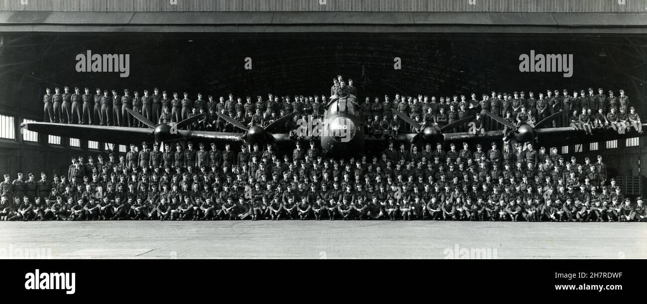 The personnel of 514 Squadron, Royal Air Force. Pictured with an Avro Lancaster bomber and its hangar. Waterbeach, Cambridgeshire, England. 1945. The squadron was formed in September 1943 and disbanded in August 1945. Post-war they flew food supplies to Holland as part of Operation Manna, and repatriated Allied POWs from Juvincourt, France. Stock Photo