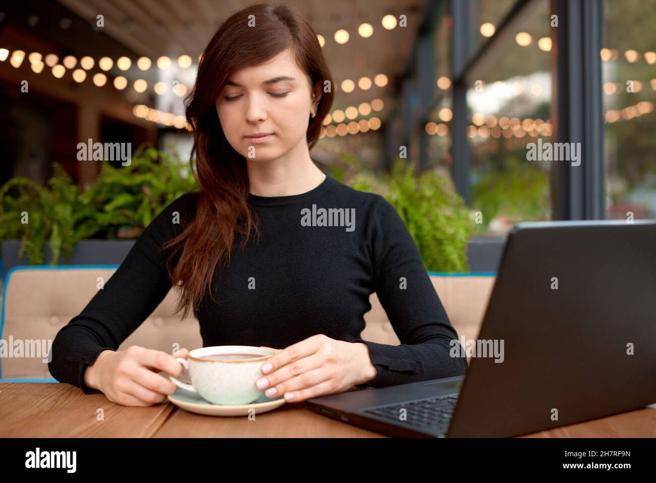 buy nothing day concept. woman use laptop and drink tea in cafe Stock Photo