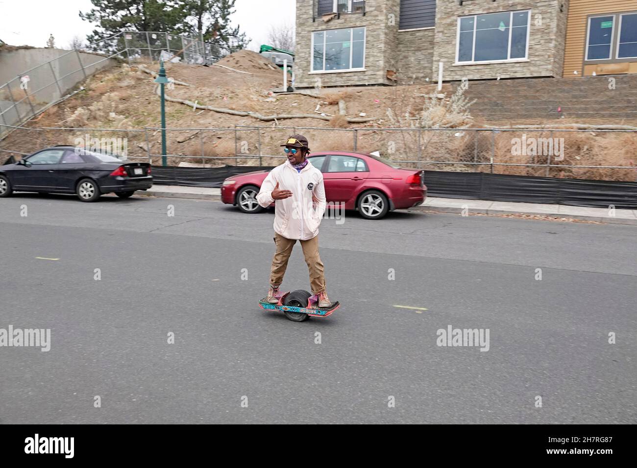 A young African-American man on a Onewheel Hoverboard, driving down a  residential street in Bend, Oregon Stock Photo - Alamy