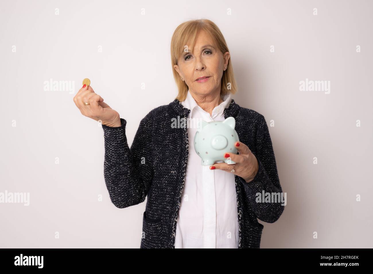 Senior woman with a piggy bank isolated over white background Stock ...