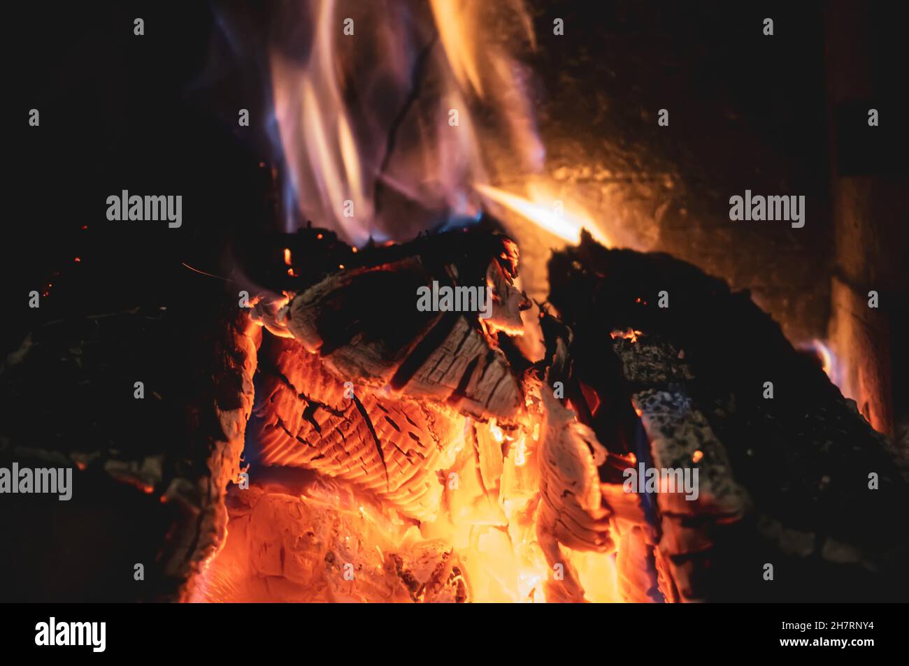 Fire burning glowing in rustic wood burning cast iron stove, log burner for heating or fireplace Stock Photo