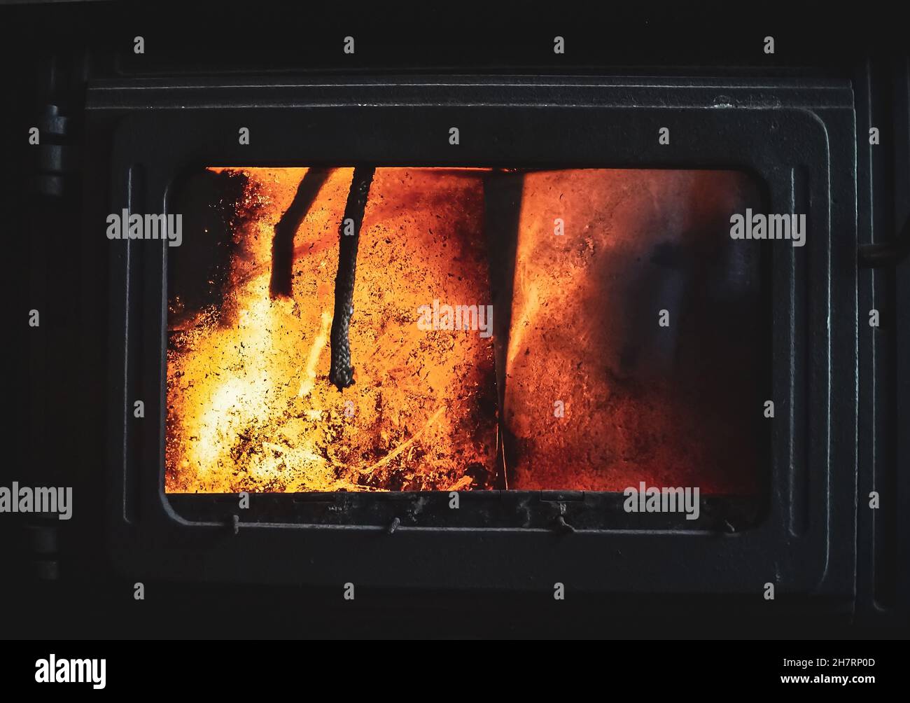 Fire burning glowing in rustic wood burning cast iron stove, log burner