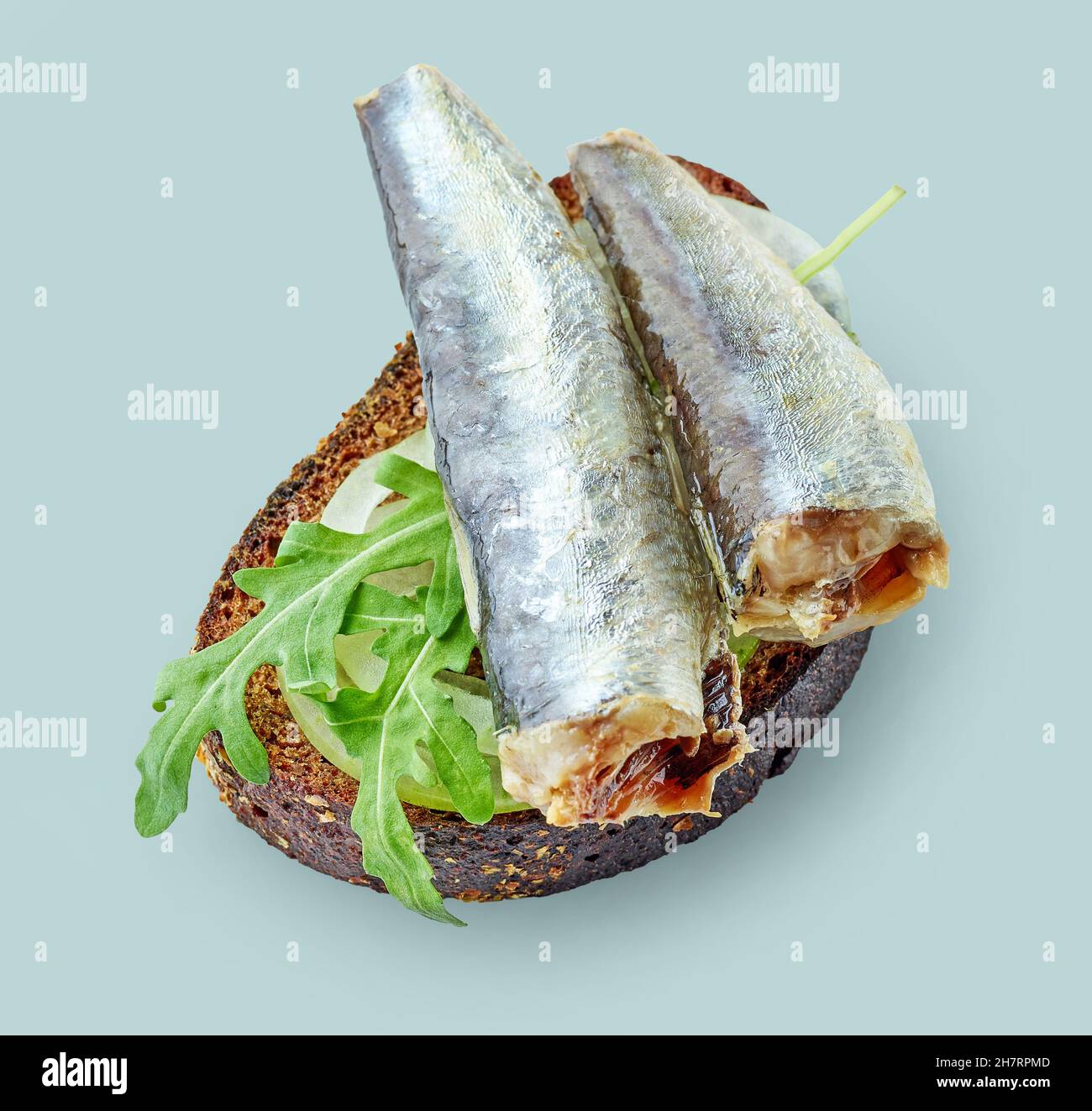canned sardines on bread slice isolated on blue background, top view
