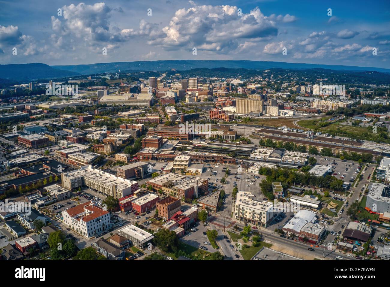 Aerial view of downtown Chattanooga with dense buildings under a blue sky with fluffy clouds