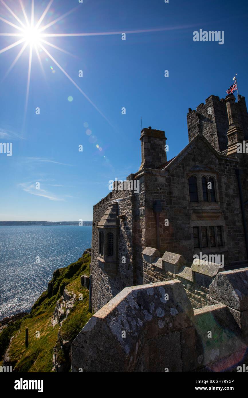 The sun over the impressive castle that sits ontop of St. Michaels Mount in Cornwall, UK. Stock Photo