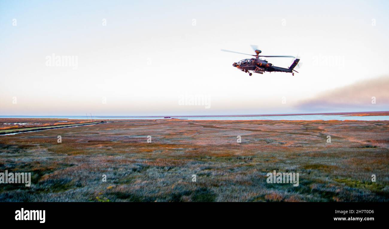 A U.S. Army AH-64E Apache helicopter flies over the Bombing Target 11 (BT-11) range on Piney Island, North Carolina, during Operation Razor Talon, Nov. 17, 2021. The BT-11 range, a satellite facility of Marine Corps Air Station Cherry Point, was used by U.S. Army Soldiers assigned to Charlie Company, 1st Battalion, 101st Aviation Regiment, 101st Airborne Division out of Fort Campbell, Kentucky. (U.S. Marine Corps photo by Lance Cpl. Lauralle Walker) Stock Photo