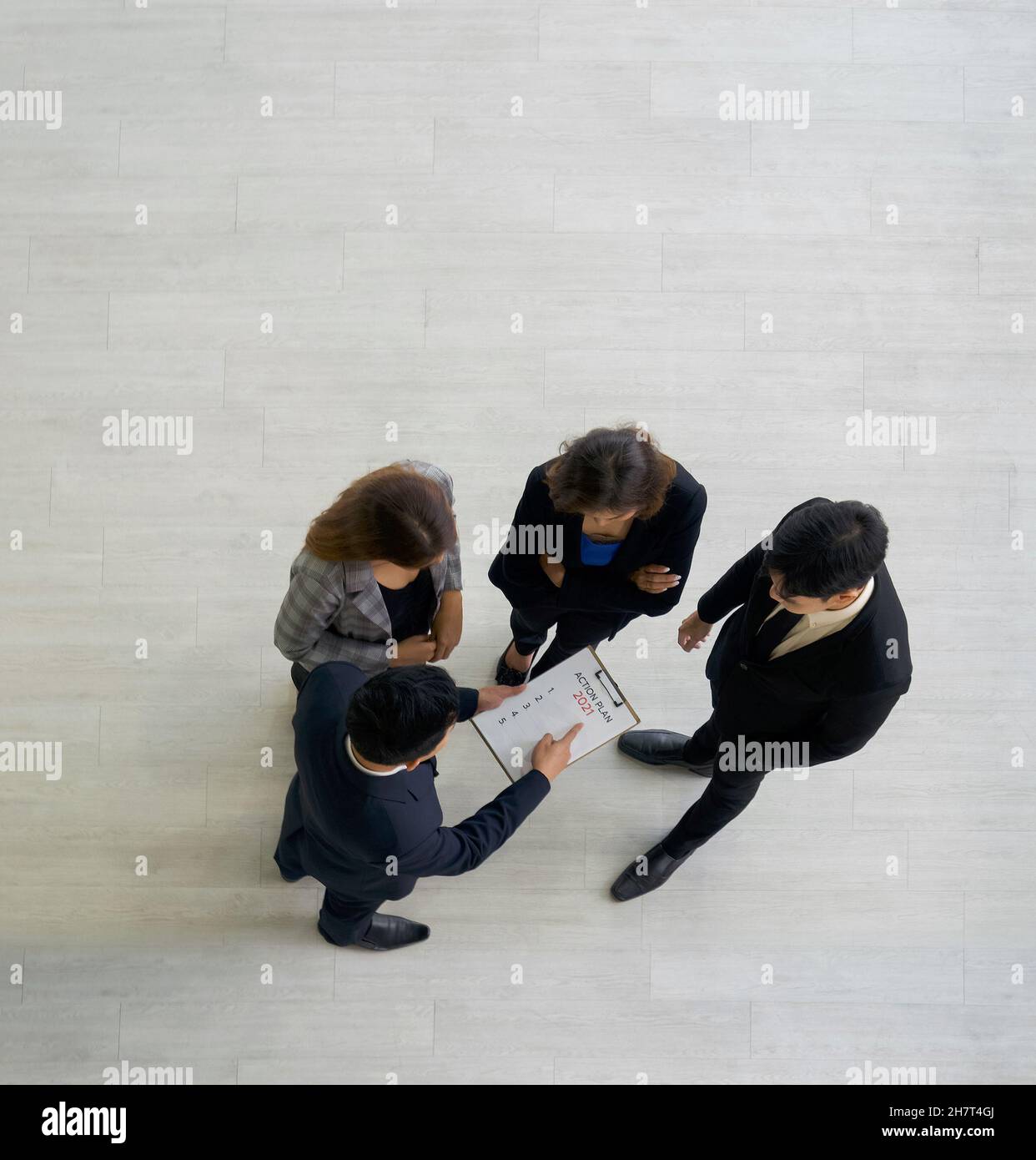 A group of business people discussing work in the hall of a modern office. People corporate business team concept. Top View Stock Photo