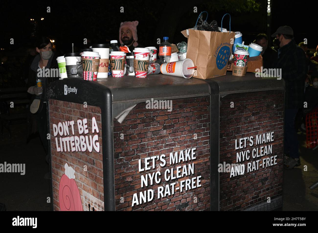 Trash from spectators placed atop full garbage cans seen at the Macy's