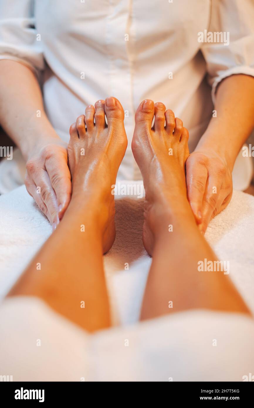 Hand's masseuse massaging woman's foot in spa salon. Healthy lifestyle. Spa body care. Stock Photo
