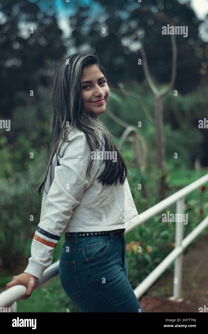 Young attractive Colombian female wearing a white shirt and jeans