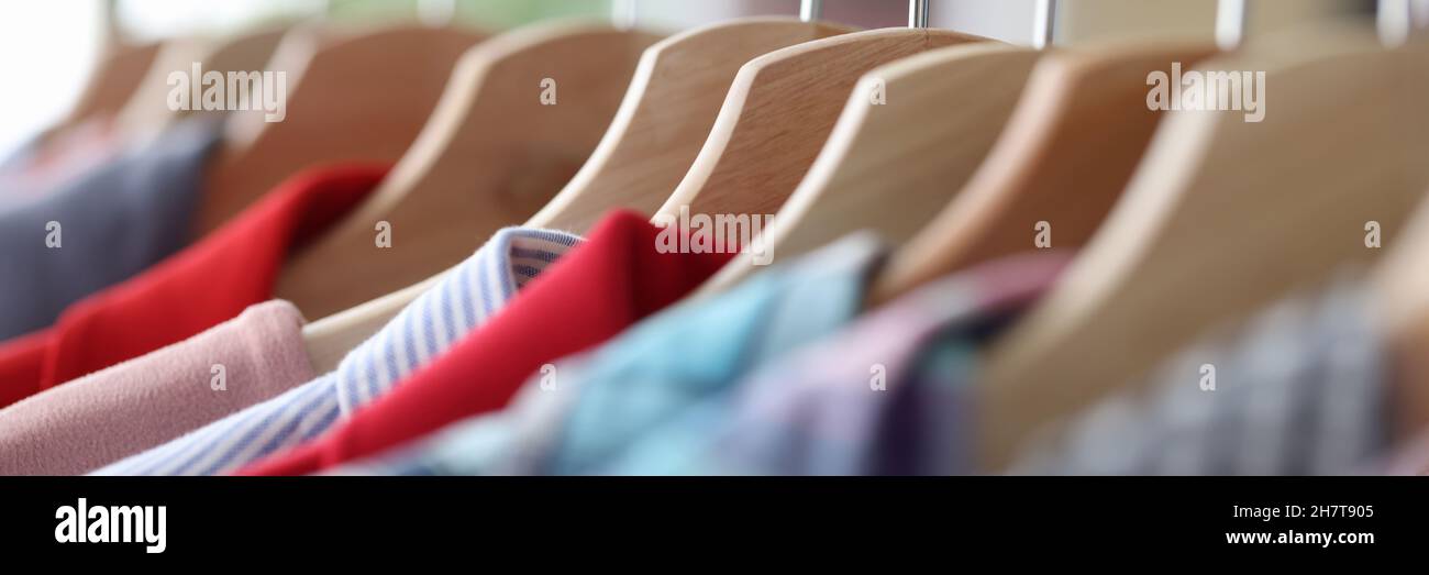 Colorful casual clothes hang on hangers closeup Stock Photo