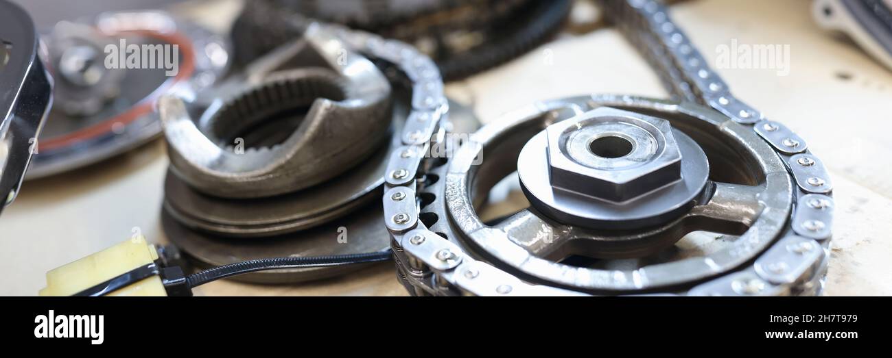 Set of cogwheels connected with steel chain lying at service table Stock Photo