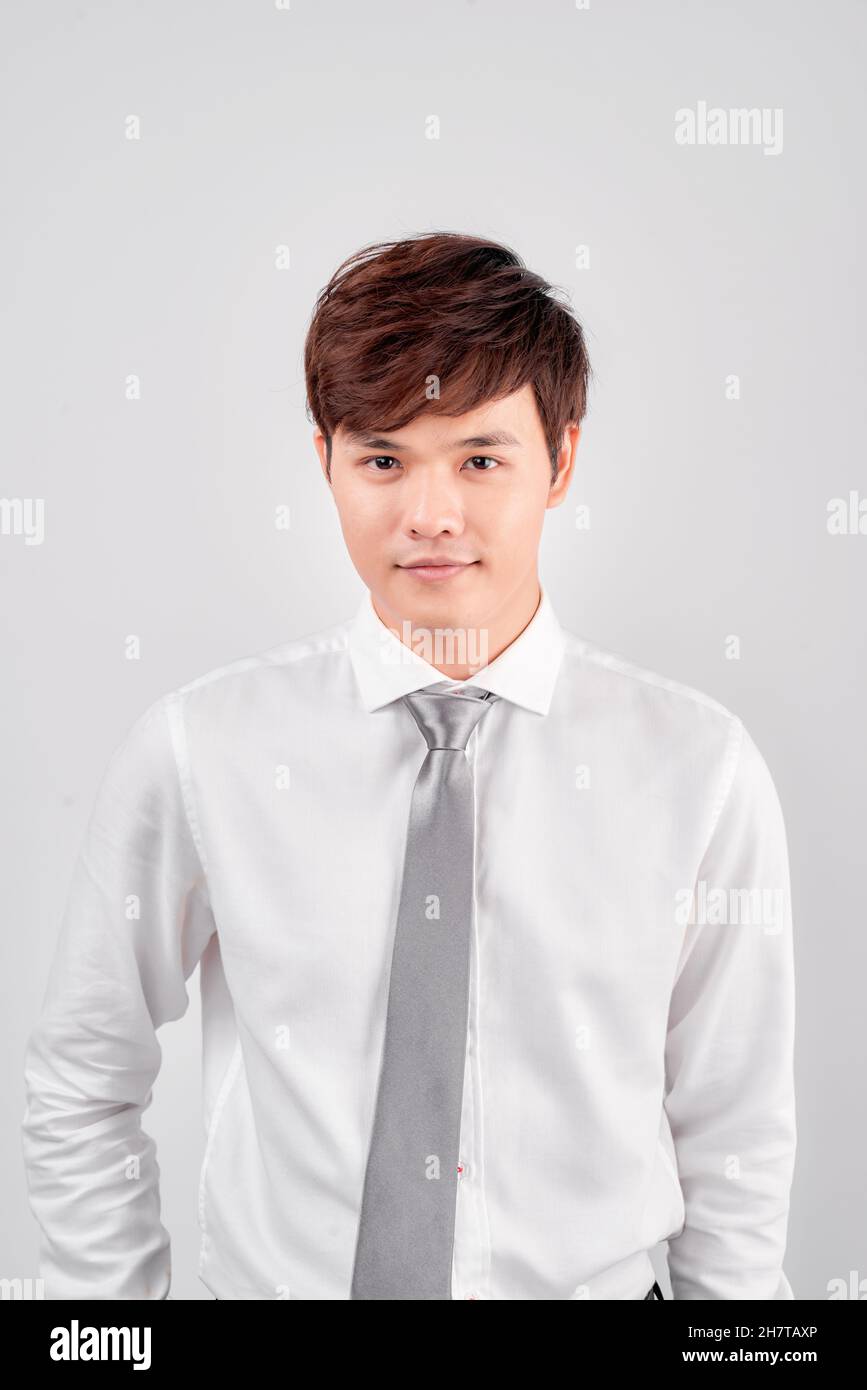 Portrait of smiling young Asian business man standing isolated on white ...