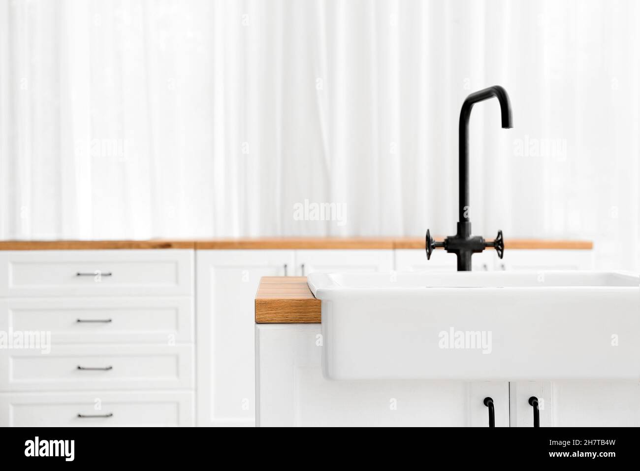 Wooden counter with sink in light kitchen Stock Photo - Alamy
