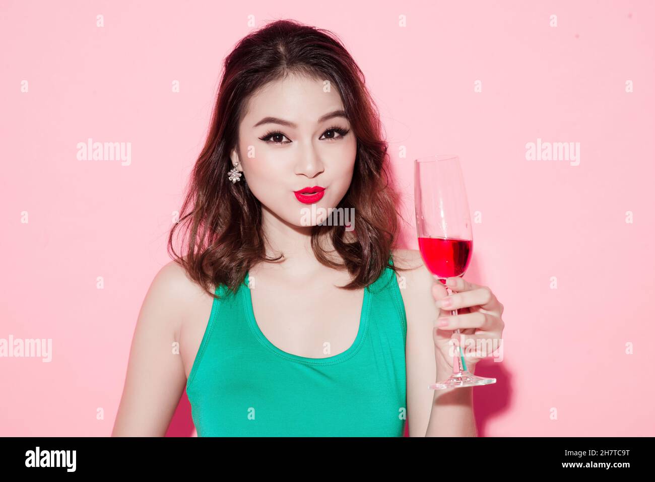Cheerful young asian woman raising glass of wine Stock Photo - Alamy