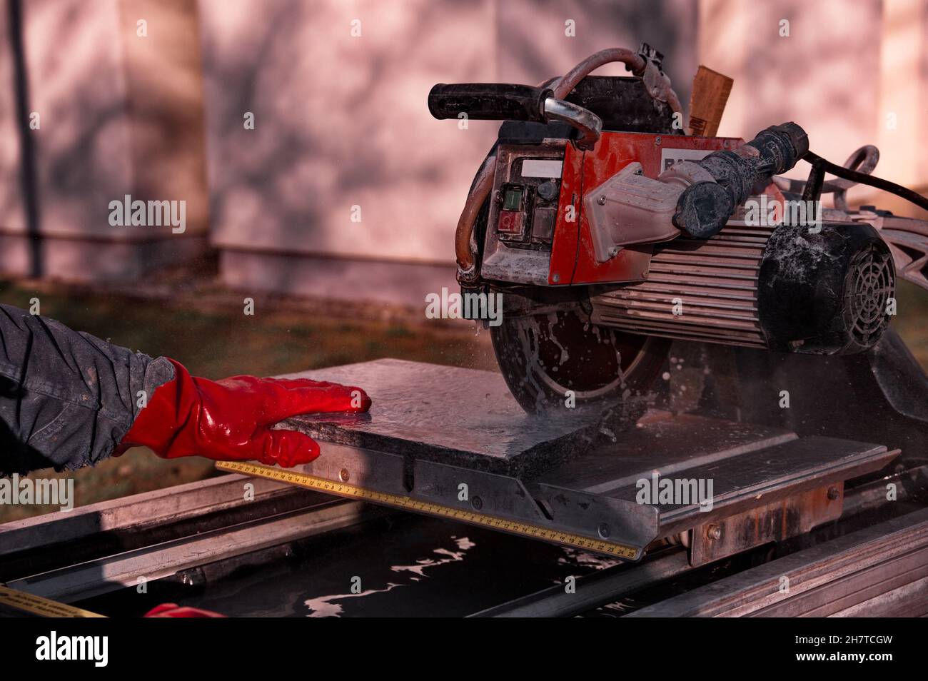 Man's hands using granite sawing machine Stock Photo