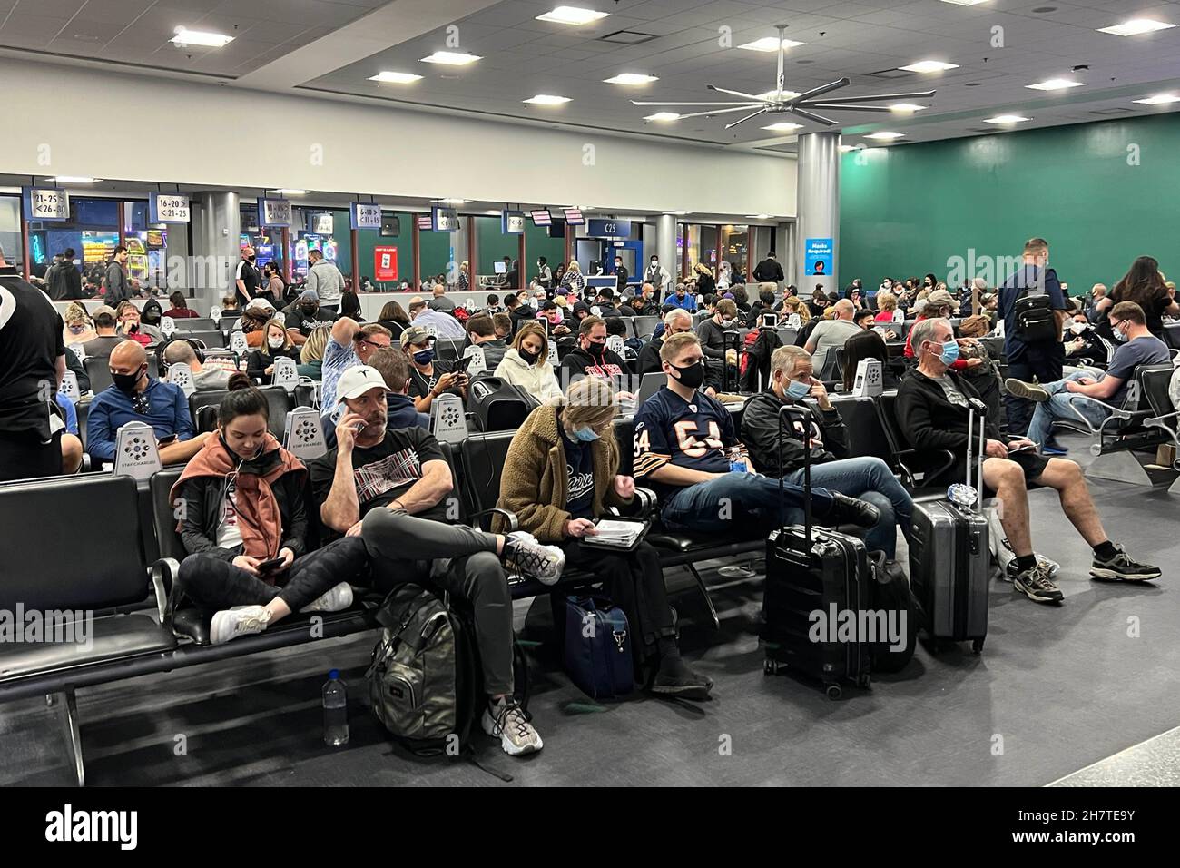 Passengers wearing facemasks wait at Gate C25 of Terminal 1 at McCarran