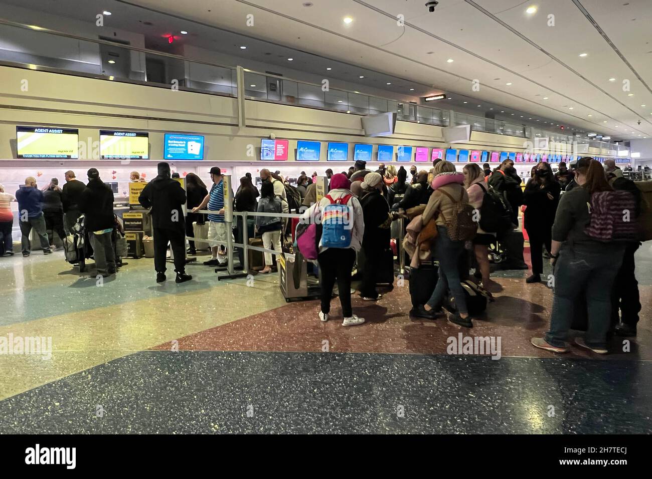 Passengers stand in line at the Spirit Airlines ticket and baggage