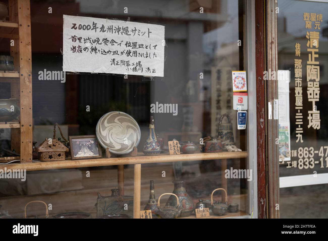 Tsuboya Potter in Tsuboya pottery district in Okinawa displaying plates made ...