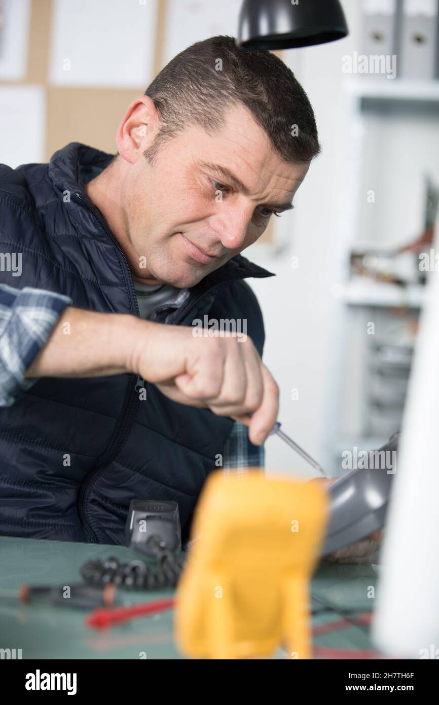 male technician repairing a landline telephone Stock Photo Alamy