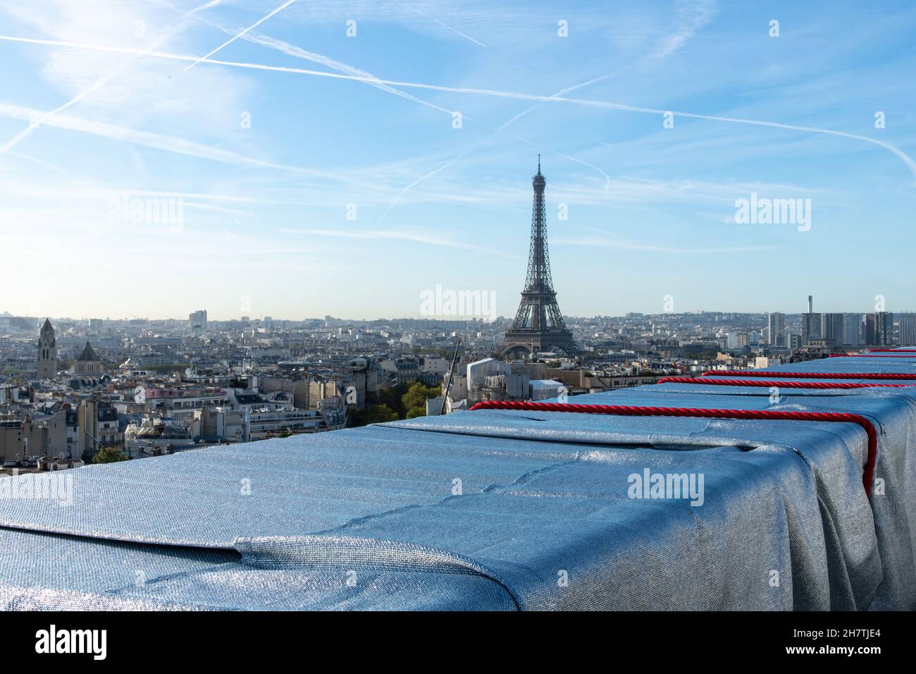Paris, France-September 2021; High level panoramic view of Eiffel Tower seen from top wrapped Arc de Triomphe art installation by Christo with red rop Stock Photo
