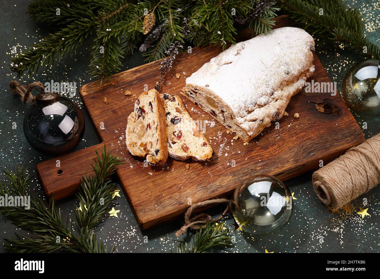 Sliced Christmas stollen cake on wooden board Stock Photo