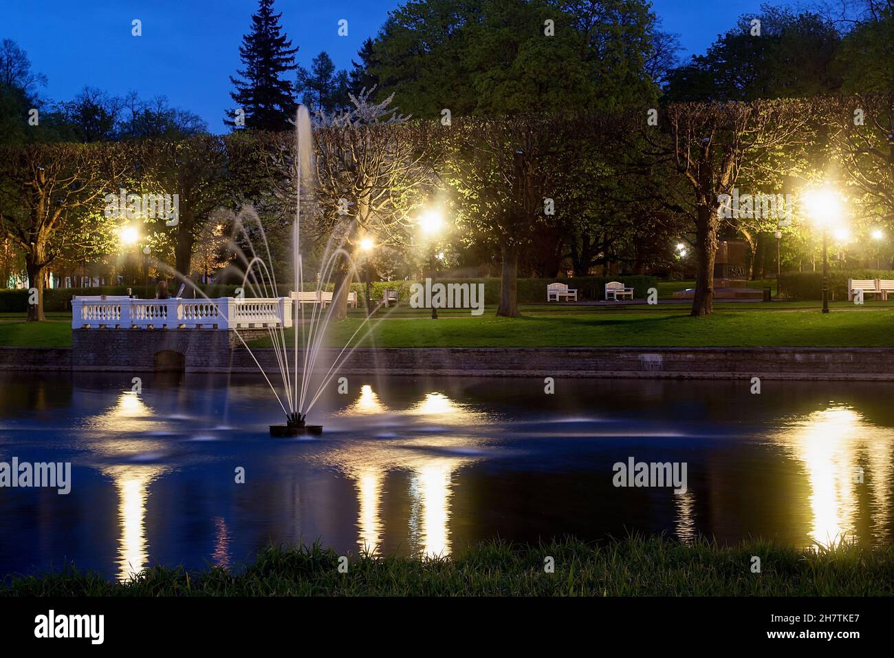 A fountain sprays the water of the Swan Lake in the Kadriorg park at Tallinn, Estonia on a quiet night. Stock Photo