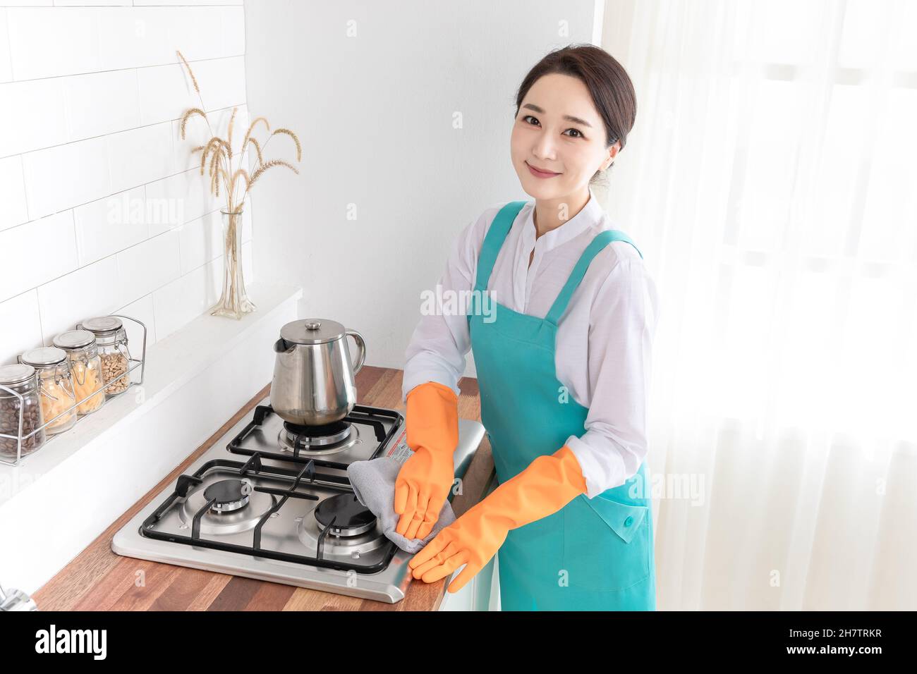 Asian woman wearing white shirt and apron, professional home cleaning service job Stock Photo
