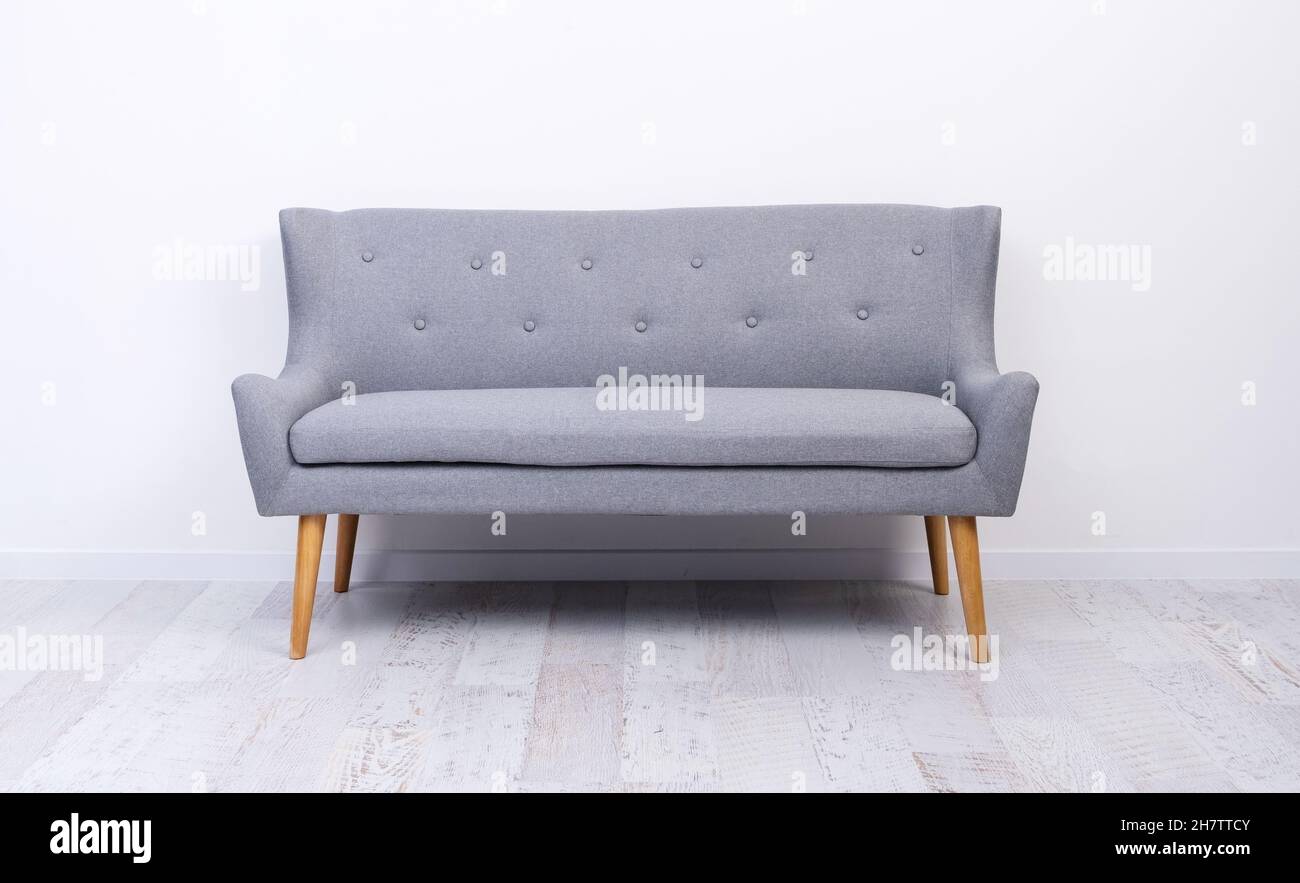 Gray couch standing on light laminate floor Stock Photo