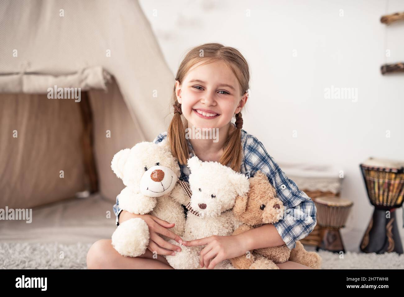 Little girl hugging plush teddies and smiling Stock Photo - Alamy