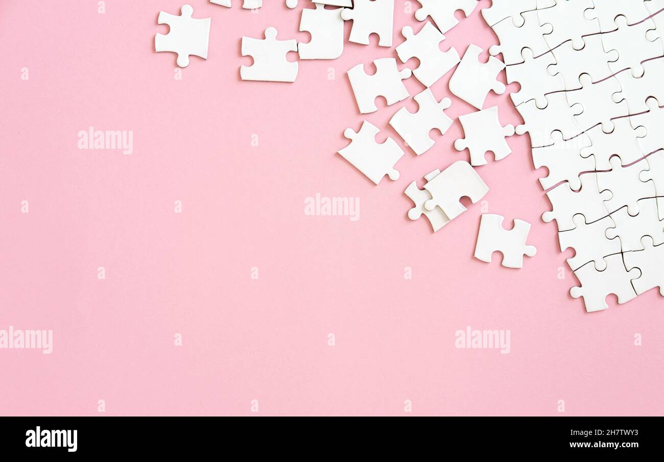 Puzzle pieces on pink background Stock Photo