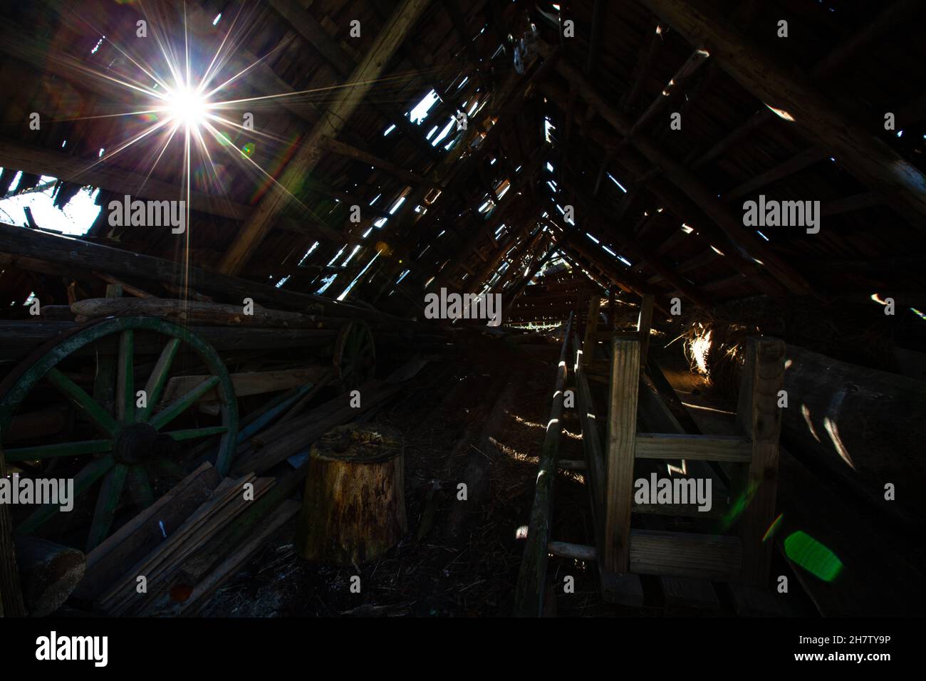 an old attic with many precious artefacts of the past, a leaky roof through which light penetrates Stock Photo