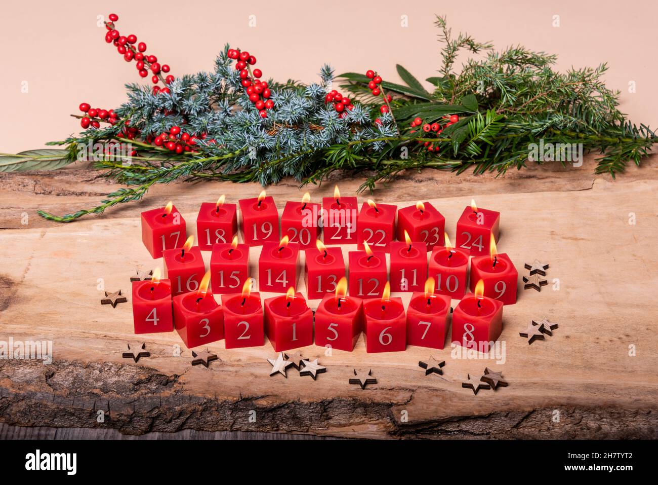 Rote Kerzen mit Weihachtsschmuck auf einem Holzbrett Stock Photo