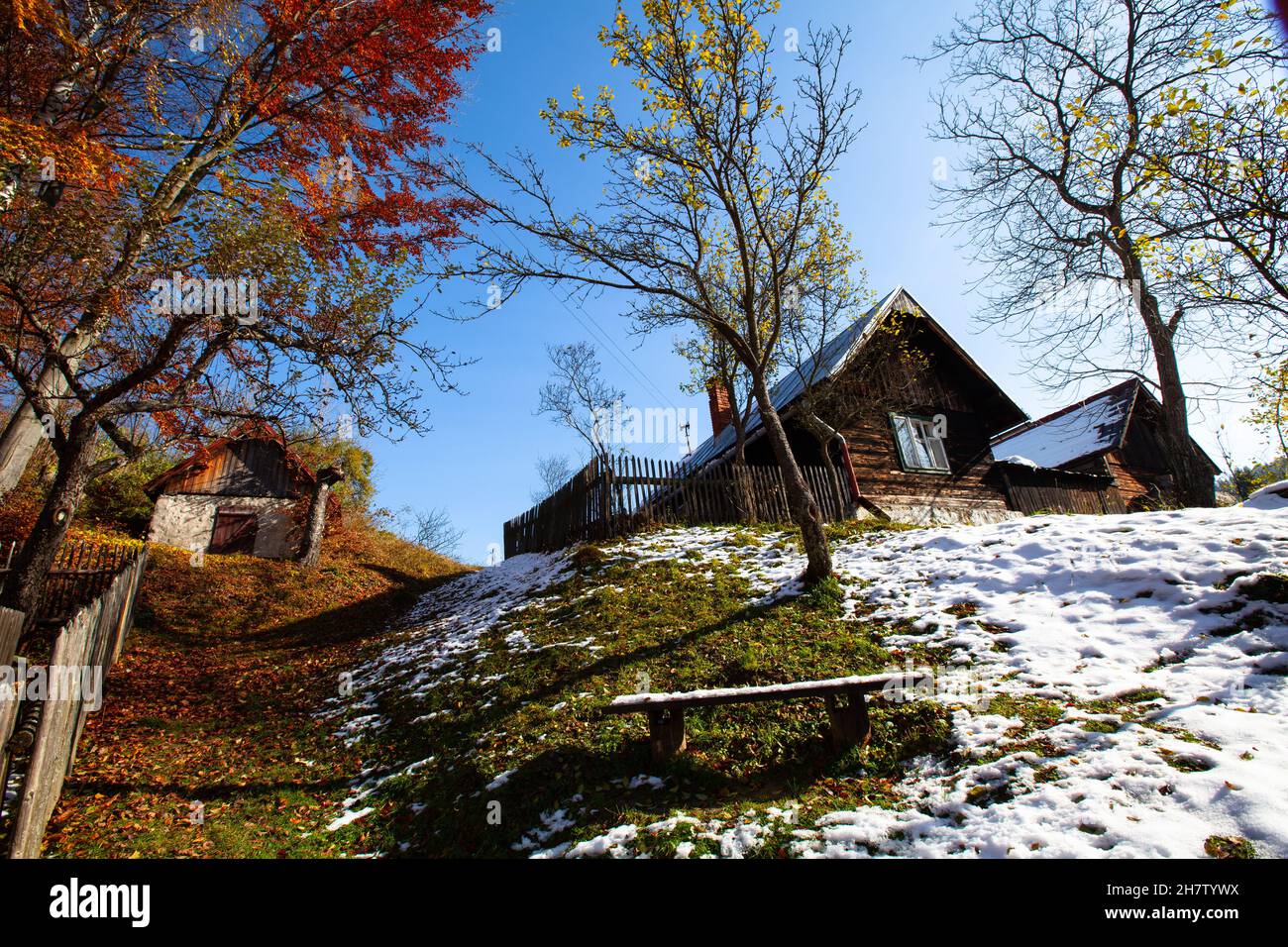 log cabin in a secluded location with old fruit trees, autumn weather in the mountains Stock Photo