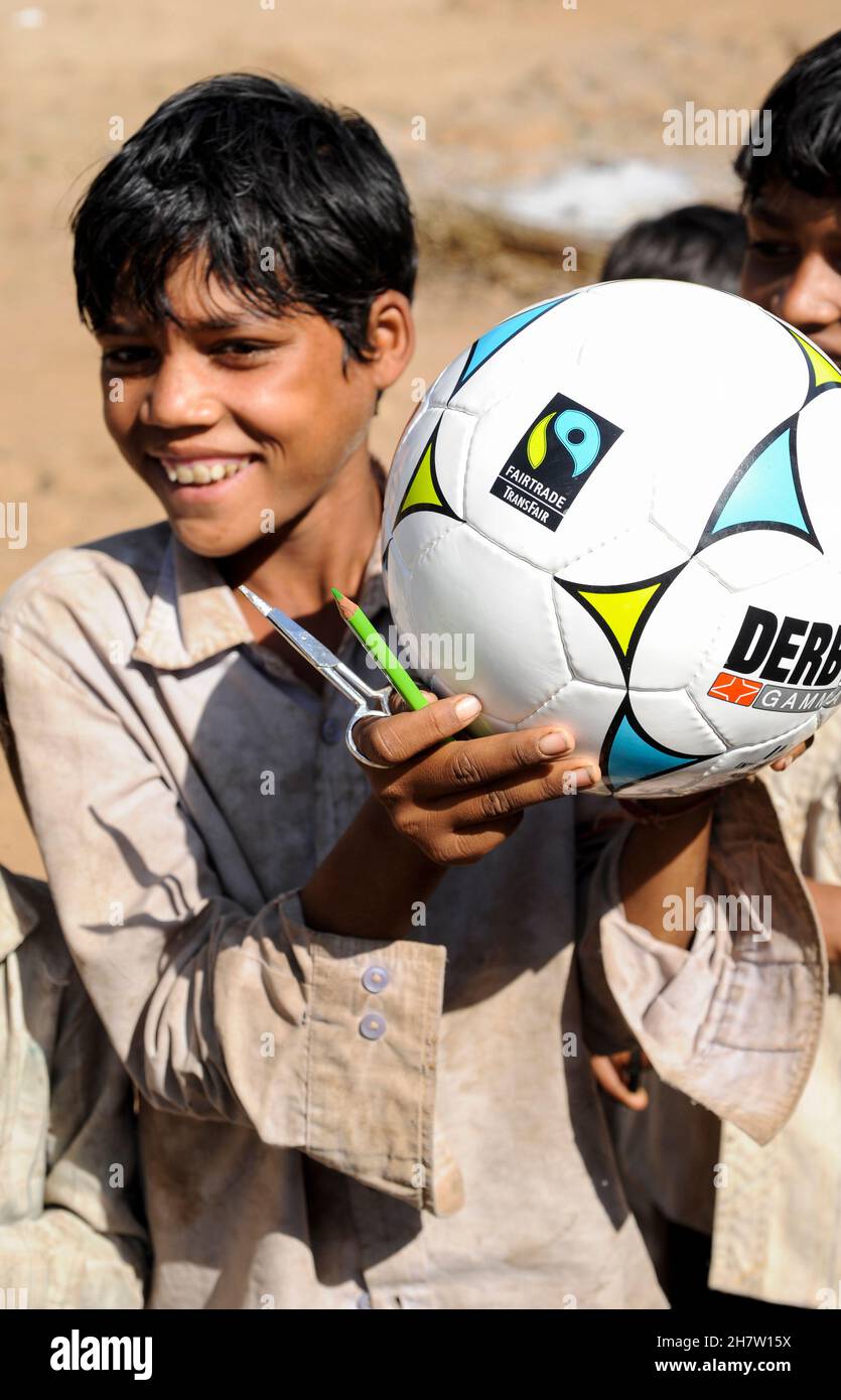 INDIA, Madhya Pradesh, laughing smiling children hold a fairtrade soccer ball , their parents a cotton farmers of a fair trade cooperative Stock Photo