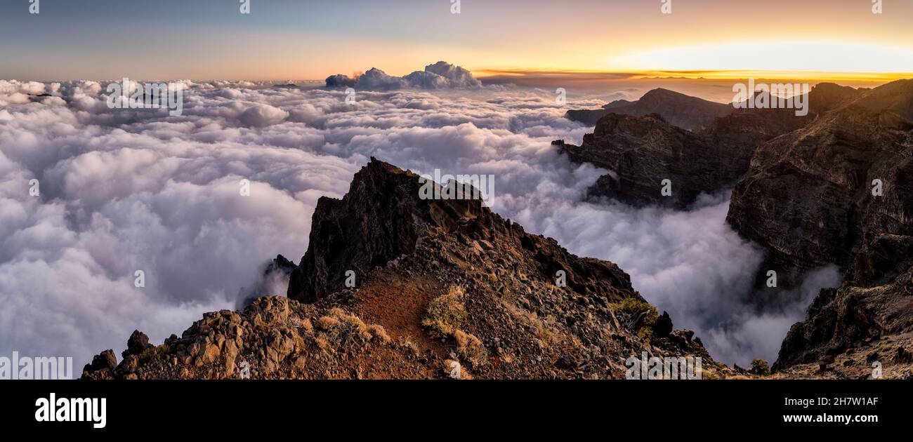 Panoramic sunset over the sea of clouds that covers the mountains of the Caldera de Taburiente in which the ash cloud expelled by the eruption of the Stock Photo