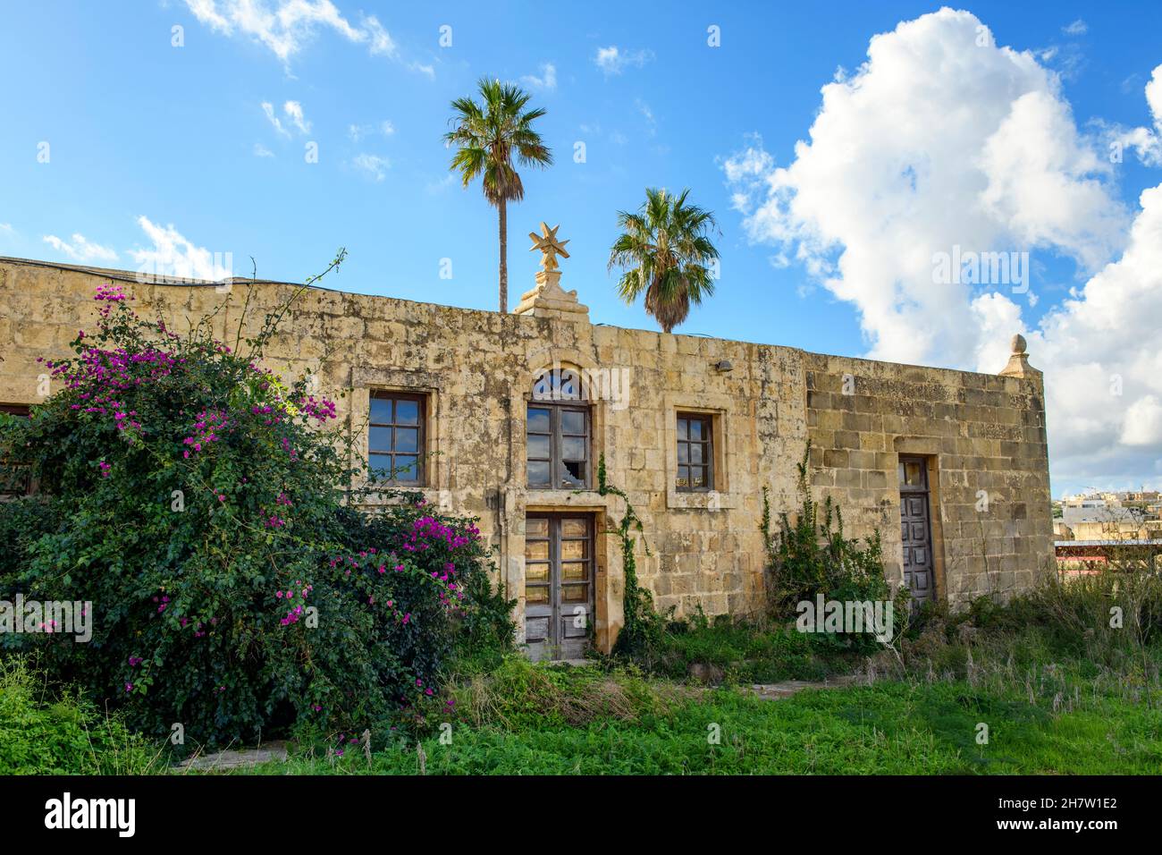historisches verlassenes Haus mit Malteserkreuz aus Kalksandstein auf Gelände von Fort Chambray, Insel Gozo, Malta, Europa Stock Photo