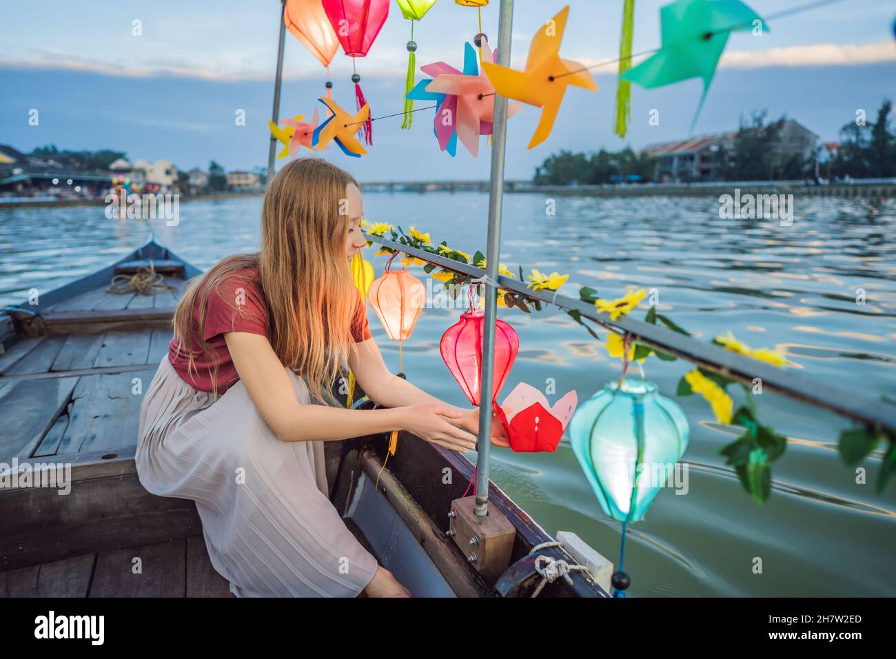 Happy woman traveler ride a national boat on background of Hoi An ...