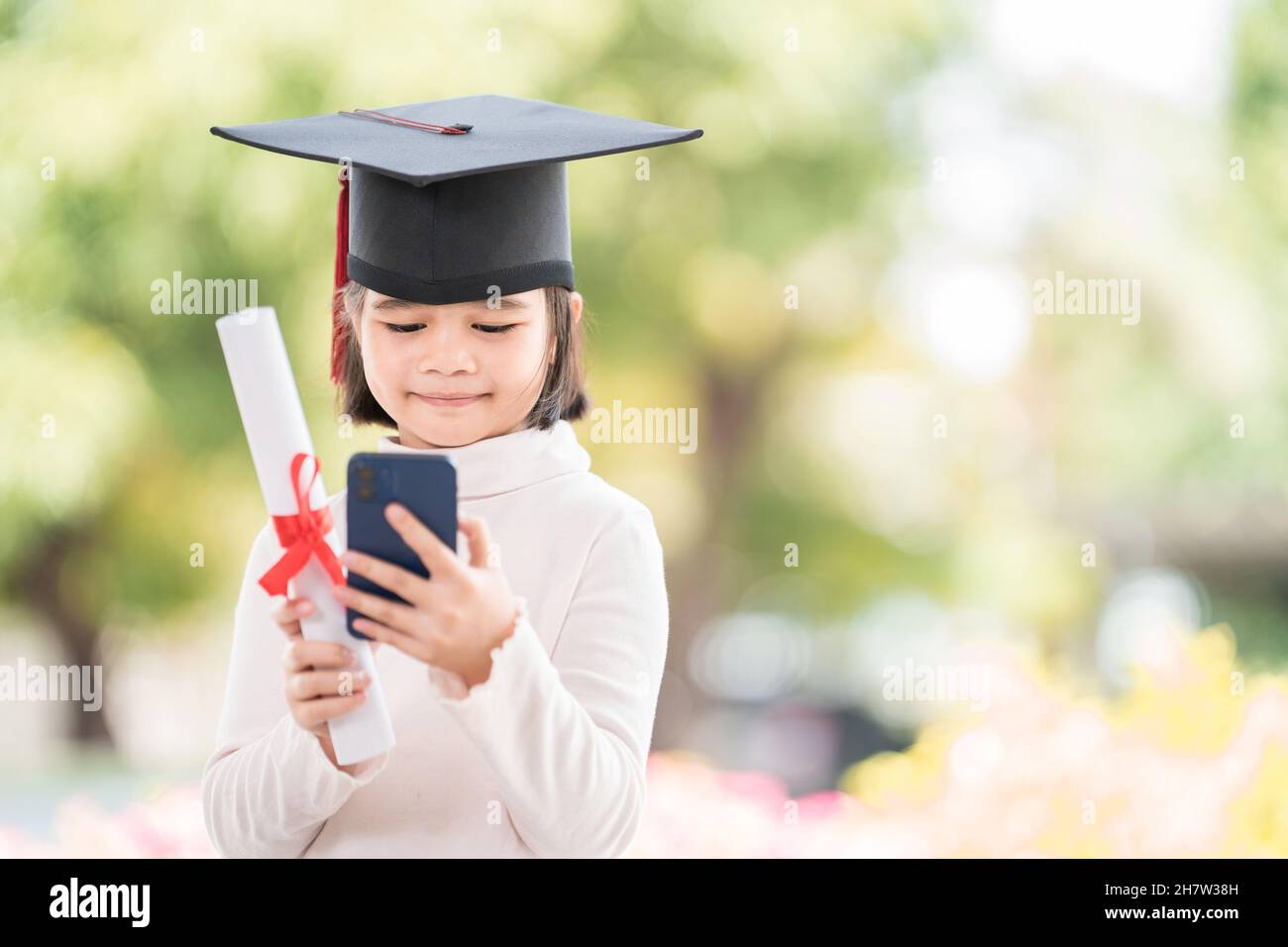 Happy Southeast Asian Schoolgirl With A Certificate And Smartphone During Graduation In Thailand 