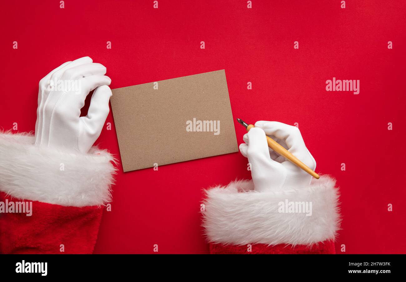 Santa Claus wiring a festive message on blank paper Stock Photo