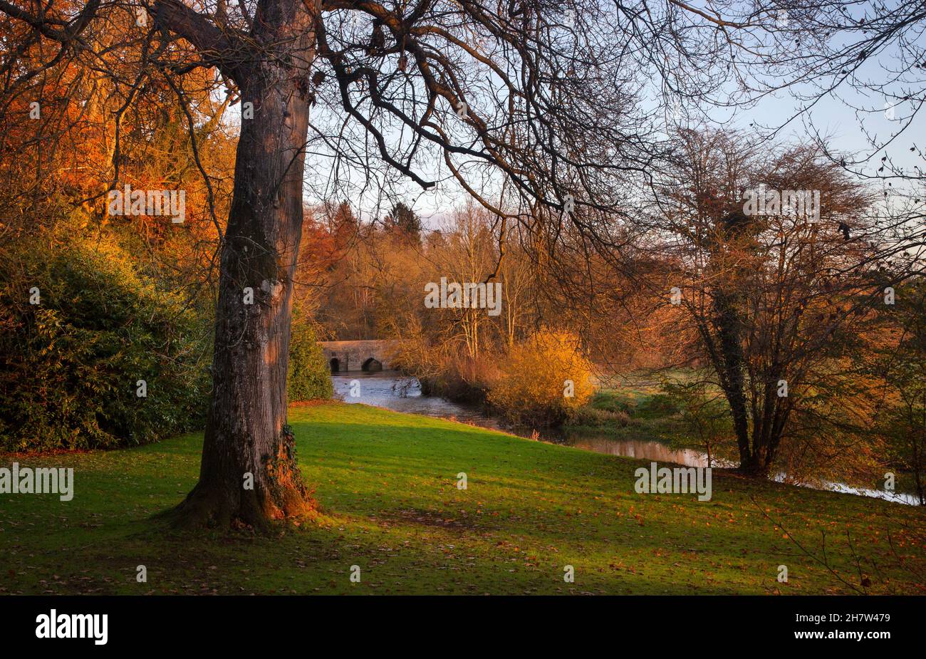 Landscaped gardens running down to river cherwell and road bridge at Rousham House, Oxfordshire,England Stock Photo