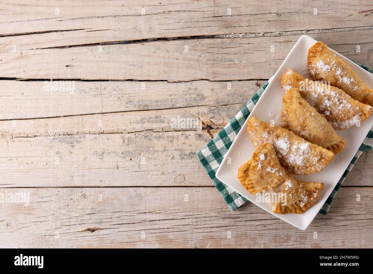 Spanish sweet stuffed pastry filled with angel hair on wooden table ...