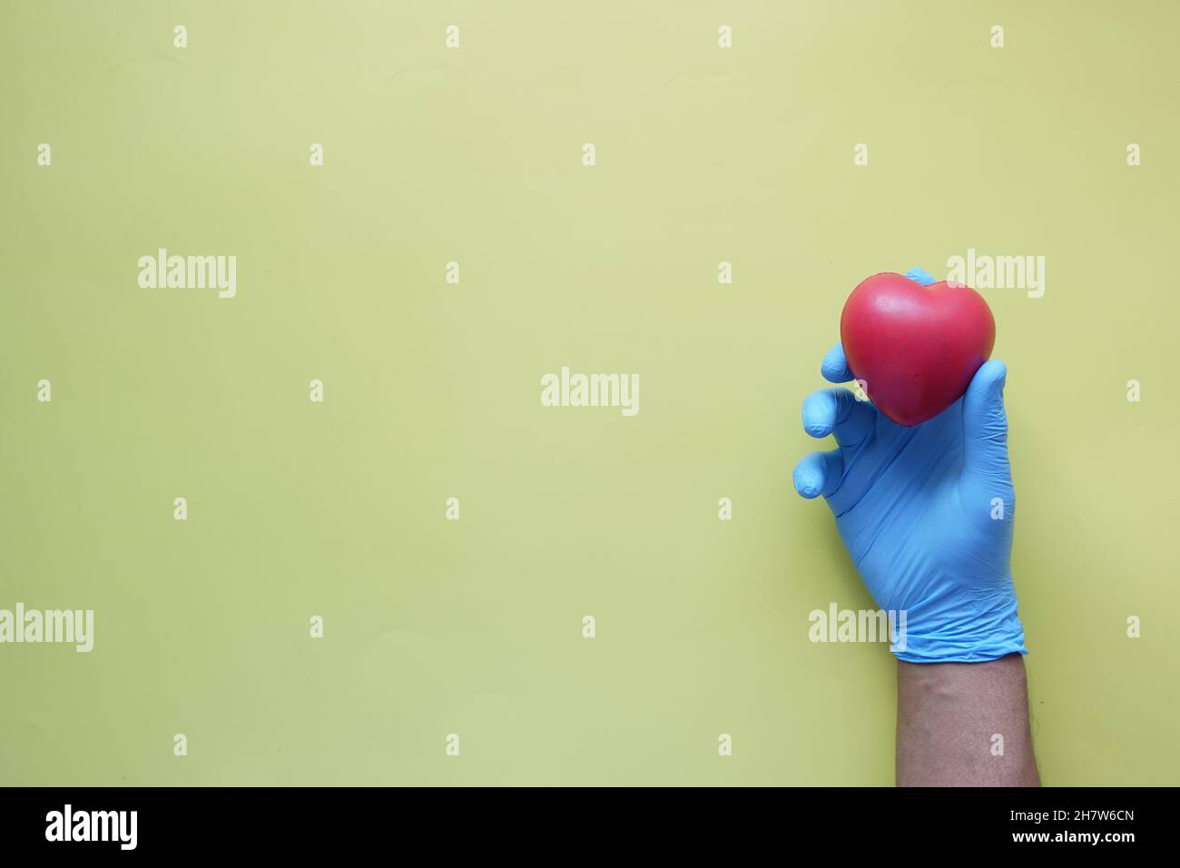 man hand in protective gloves holding red heart  Stock Photo