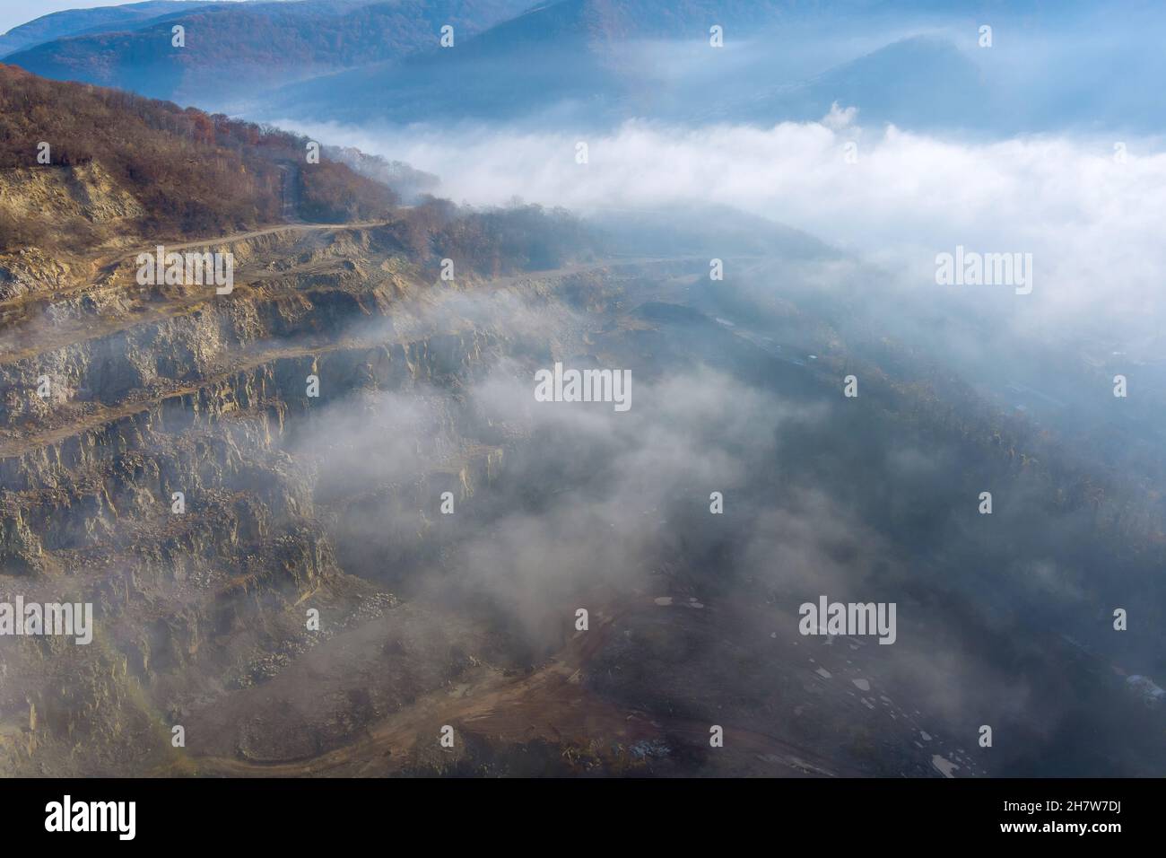 Aerial top view of landscape morning fog on mountain with quarry